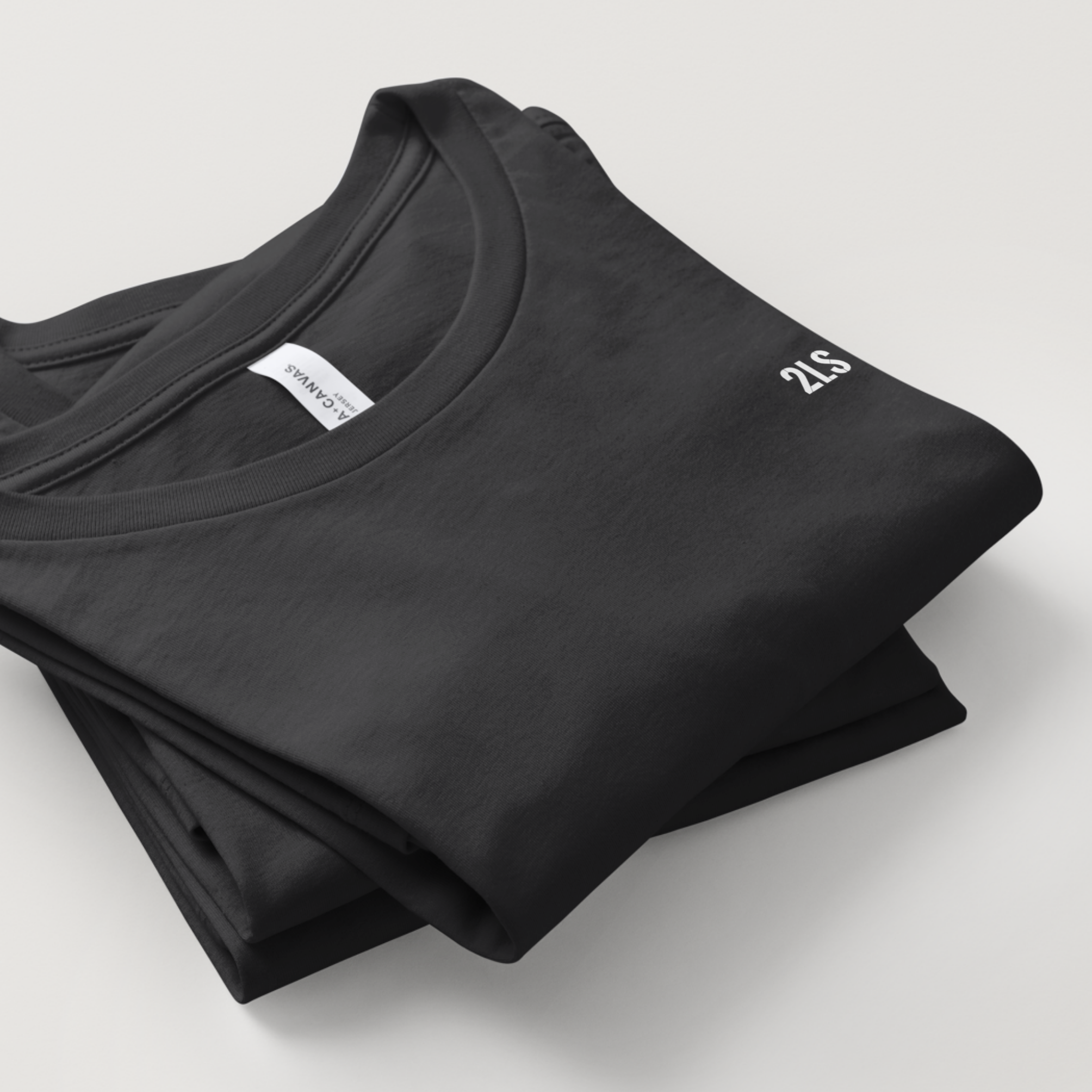 Folded black t-shirt with a brand label on a light gray background 2lowisierra 2LS tshirt