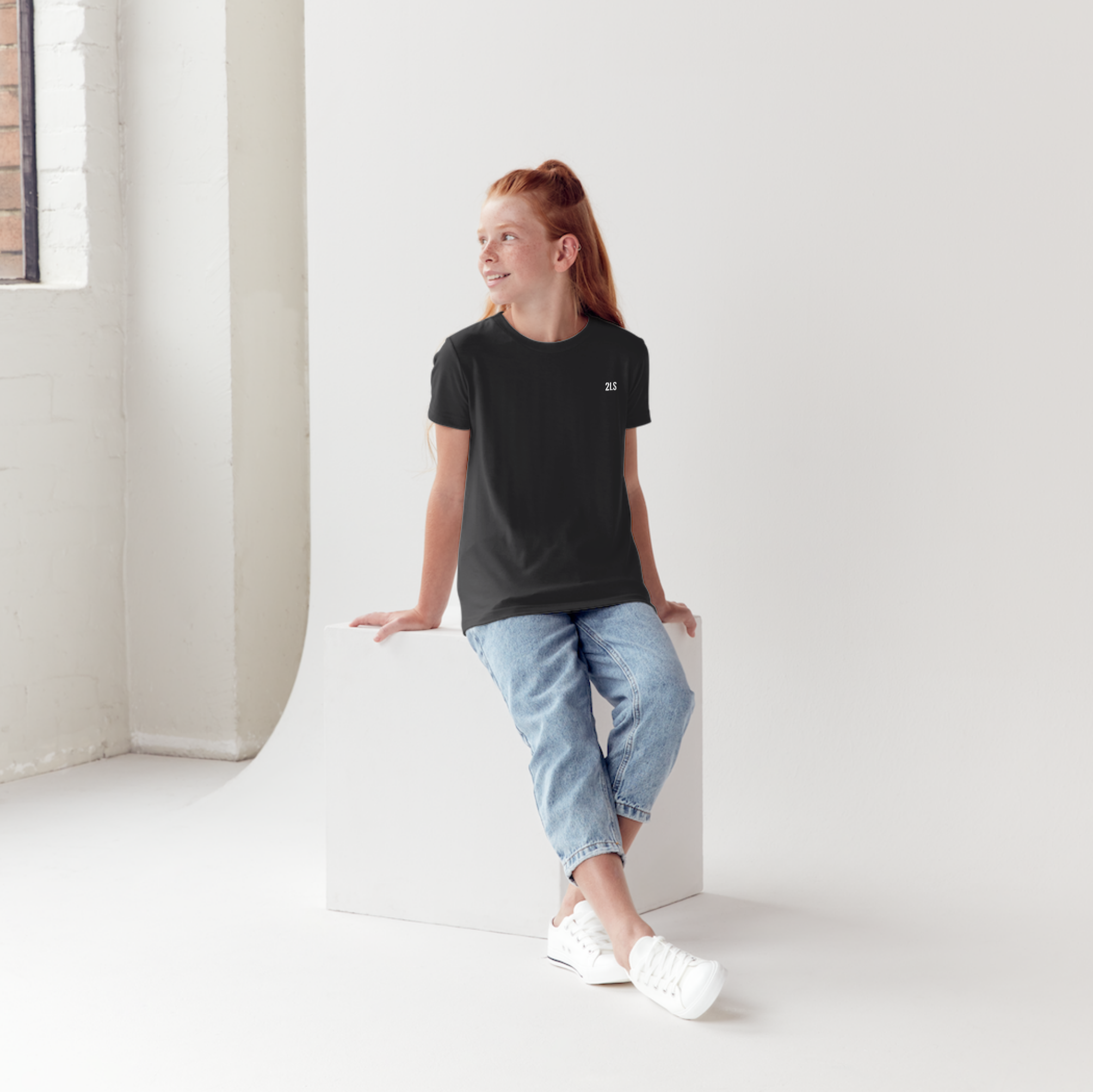 Woman sitting on a white block in a minimalistic room
